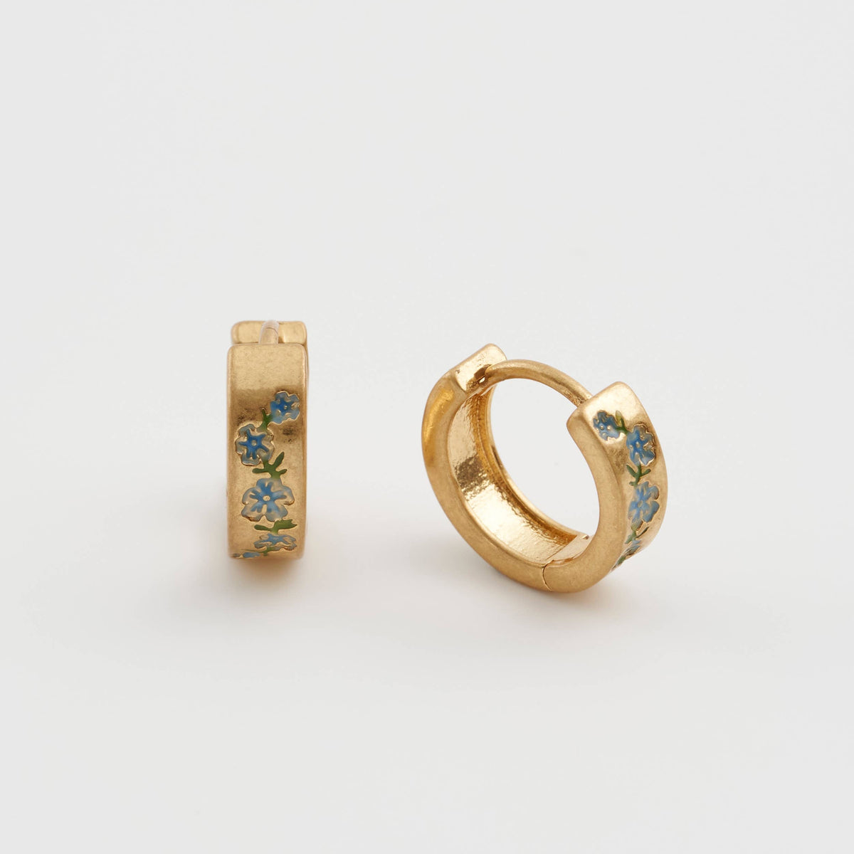 Forget-me-not hoop earrings pair, one upright one angled, white background