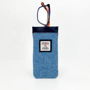 Glasses peeking out from the top of a Harris Tweed sleeve in herringbone sky blue fabric.