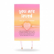 Elasticated rose quartz heart bracelet on card with “You Are Loved” message, ideal self-love or friendship gift.
