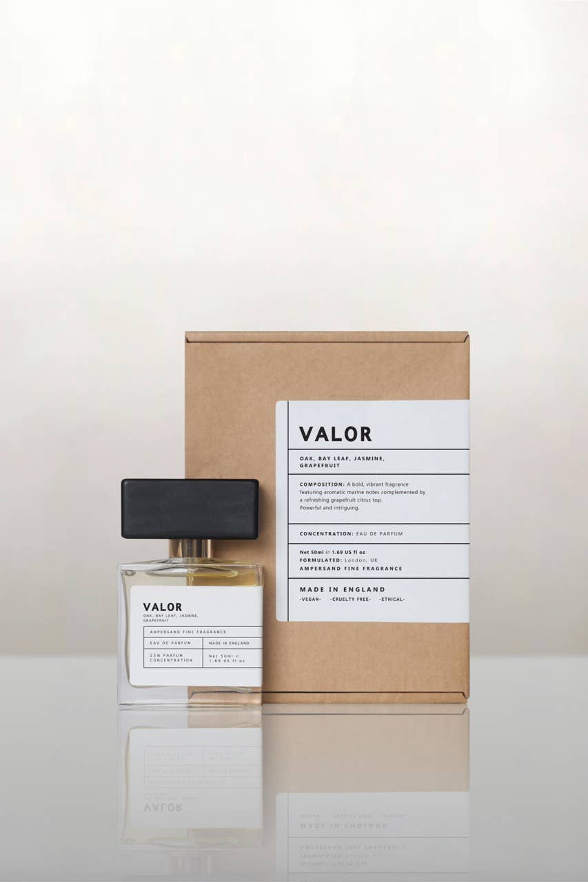 Valor perfume bottle beside its recycled kraft gift box, cream background
