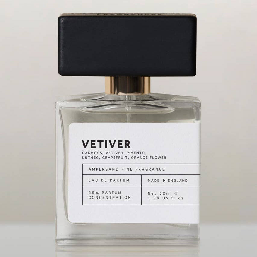 Vetiver eau de parfum bottle with black cap, front view on cream background