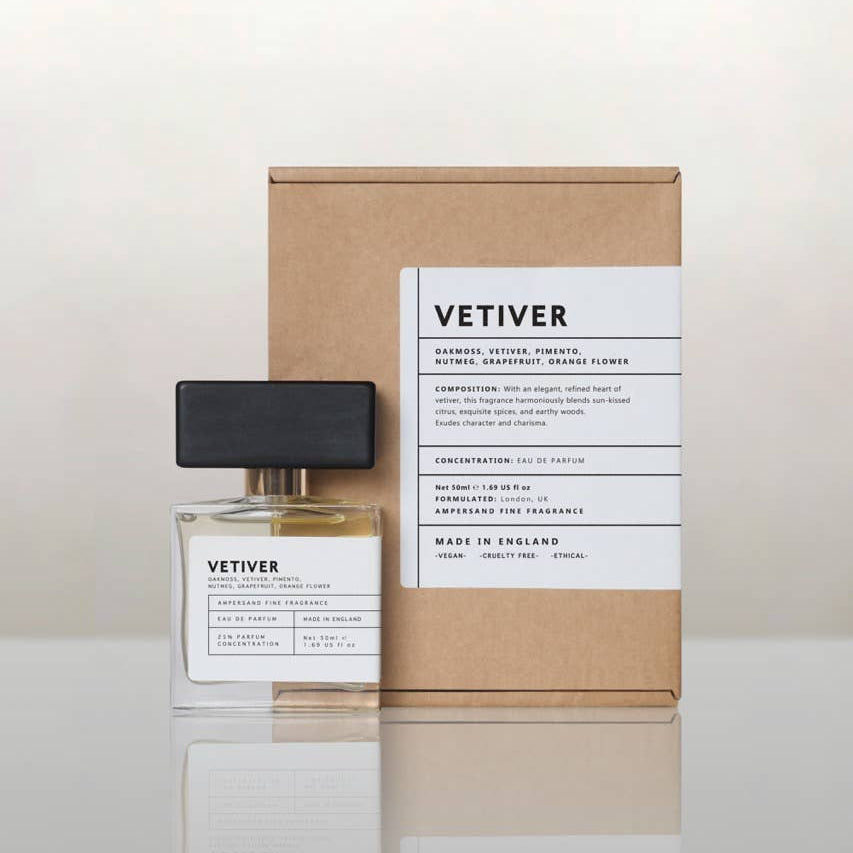 Vetiver perfume bottle beside its recycled kraft gift box, cream background