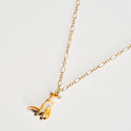 Close-up of hand-painted enamel fox charm on gold chain, white background