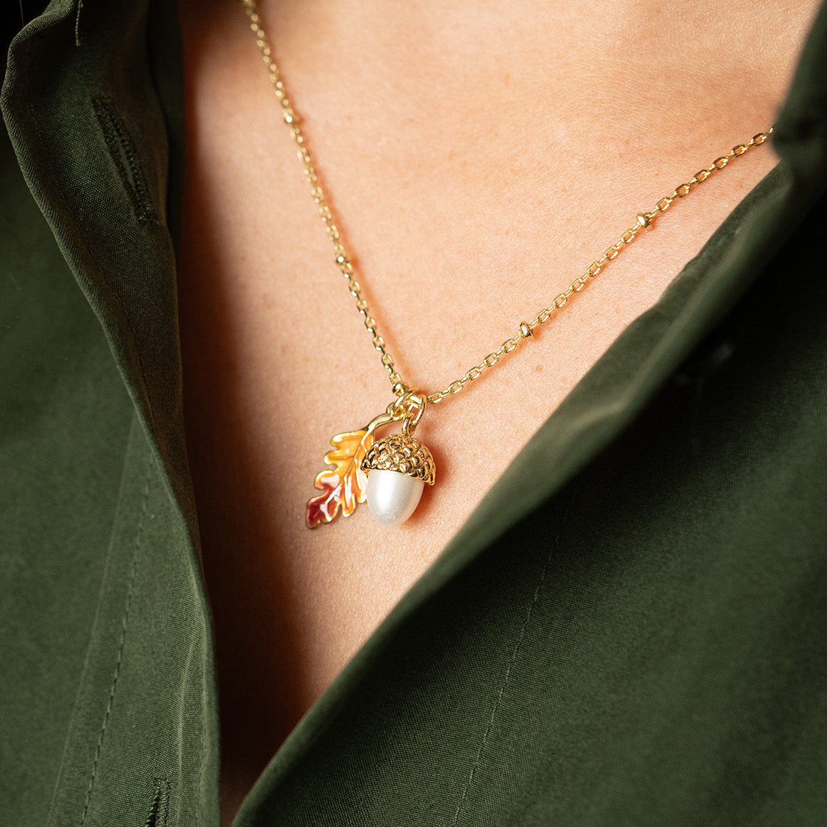 Acorn and Oak Pendant necklace worn with a dark green shirt