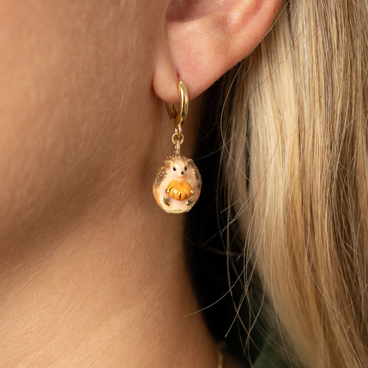Hedgehog and Pumpkin Huggie Earring worn, with long blonde hair