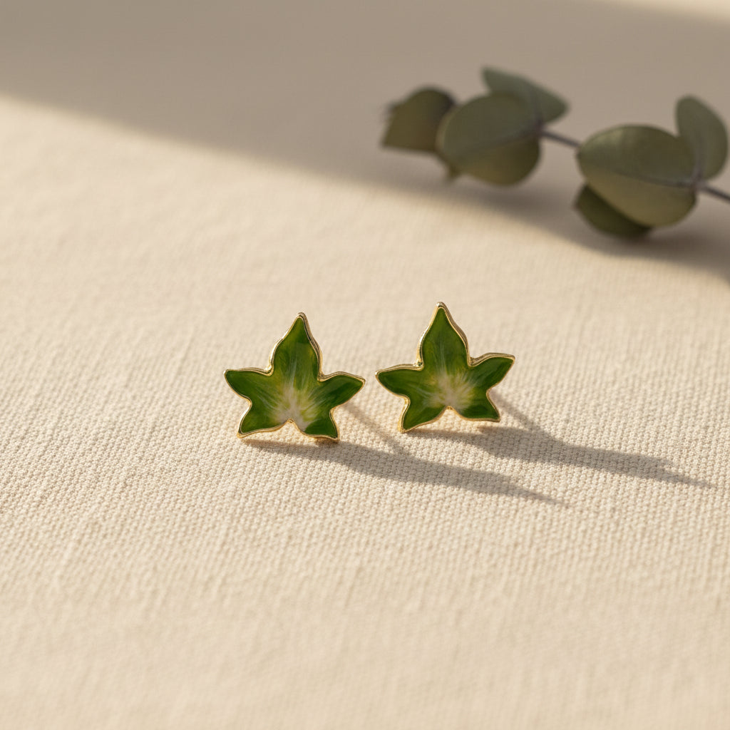 Bill Skinner Ivy Stud Earrings, green leaves with gold edges, on white