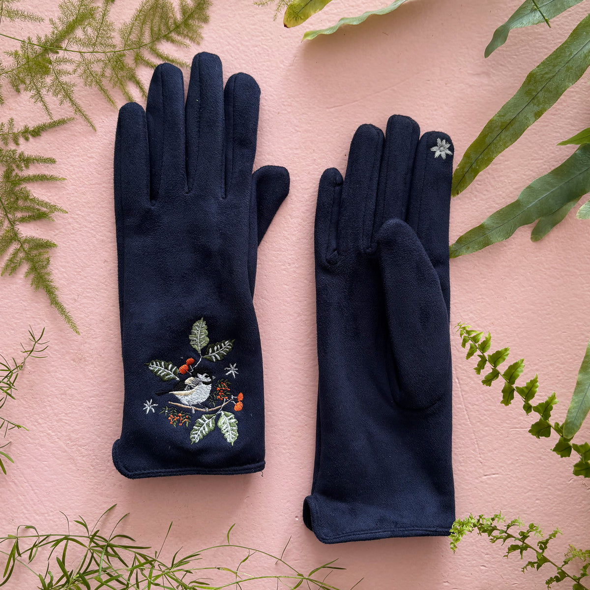 Both bird gloves flat showing embroidered fronts on pink background with greenery