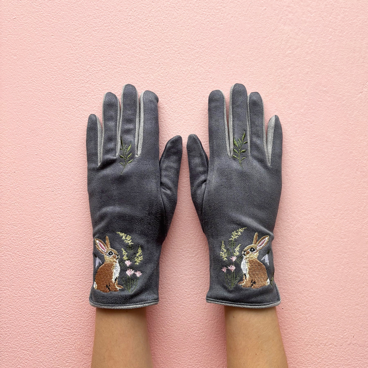 Grey embroidered rabbit gloves pair showing front design on pink background