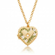 Close-up of Jasmine Heart Locket Necklace with hand-painted enamel lilies and faux pearl detail.