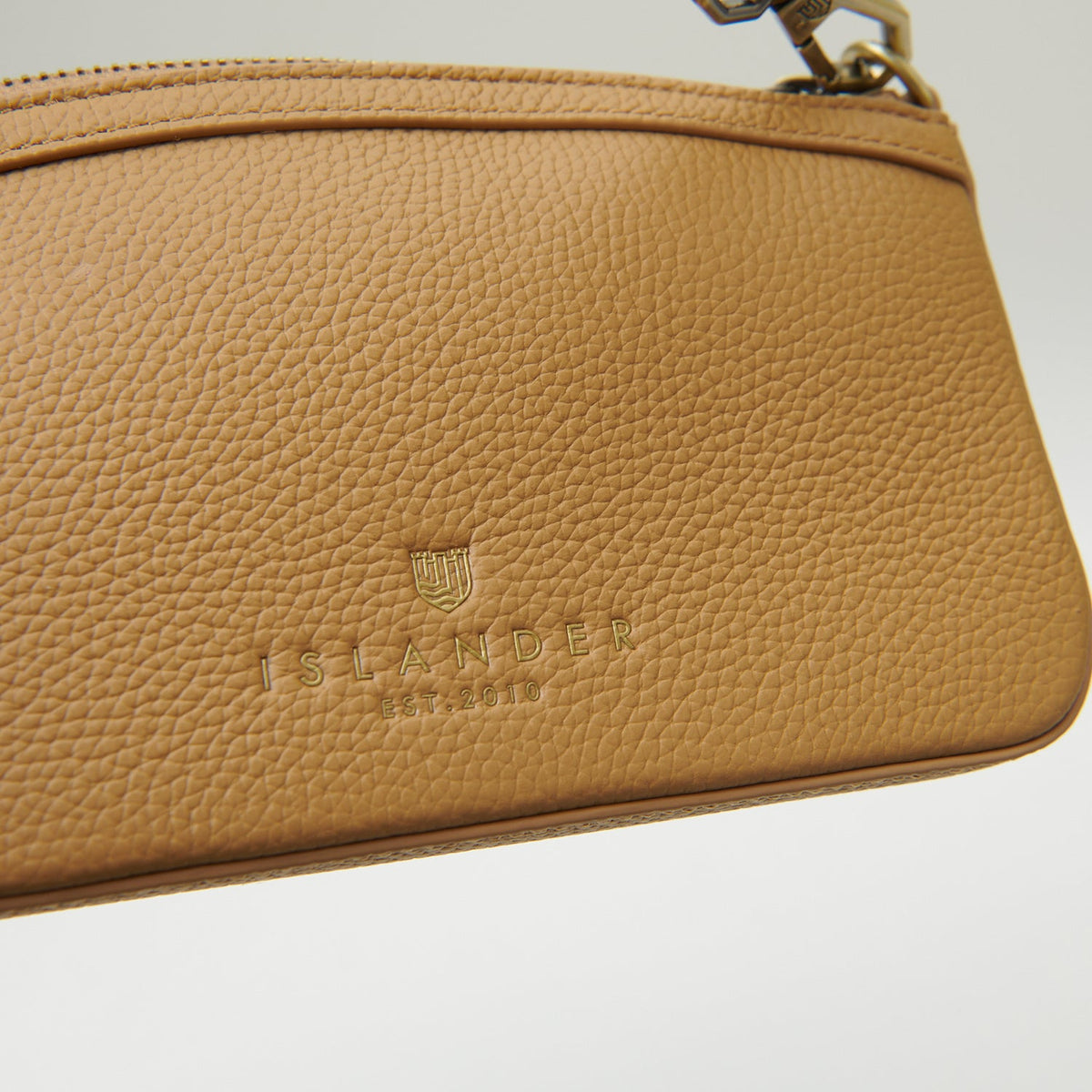 Close-up of embossed Islander branding on tan leather back panel