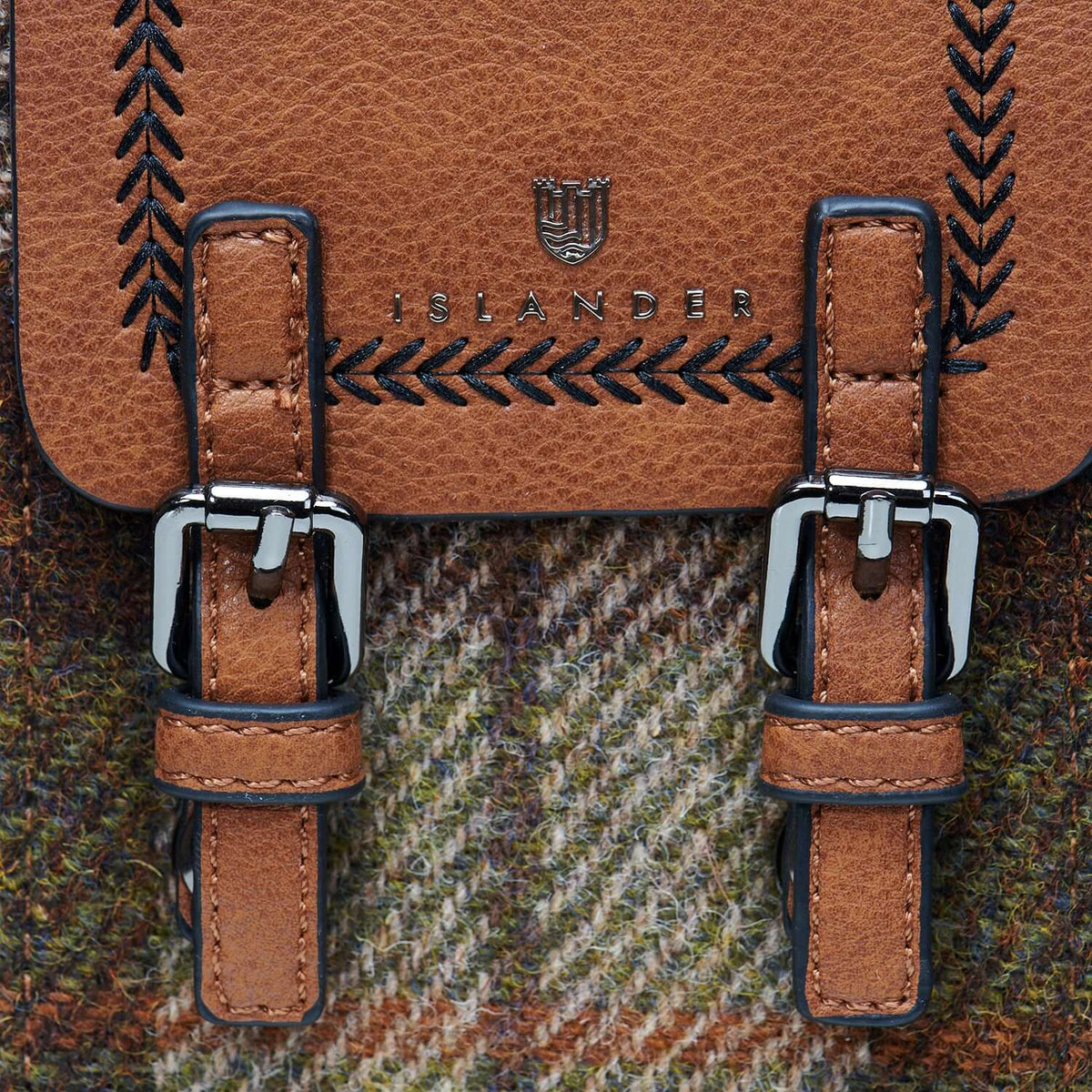 Close-up of the chestnut tartan Harris Tweed phone tote bag, highlighting its sturdy metal buckles and intricate fabric detail.