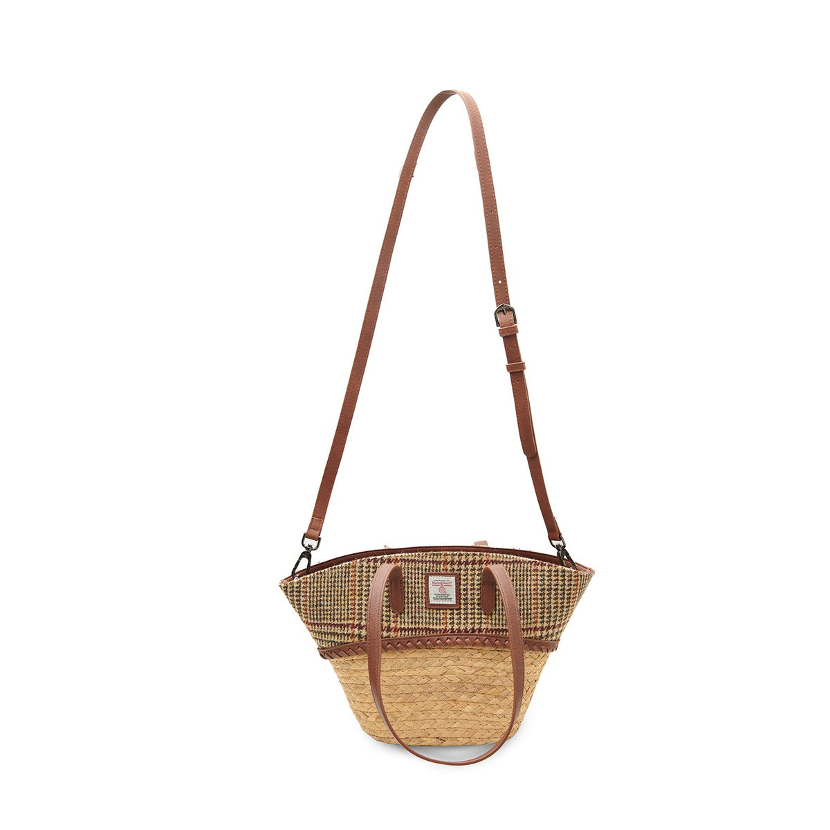 Beige dogtooth basket bag worn crossbody with the strap fitted