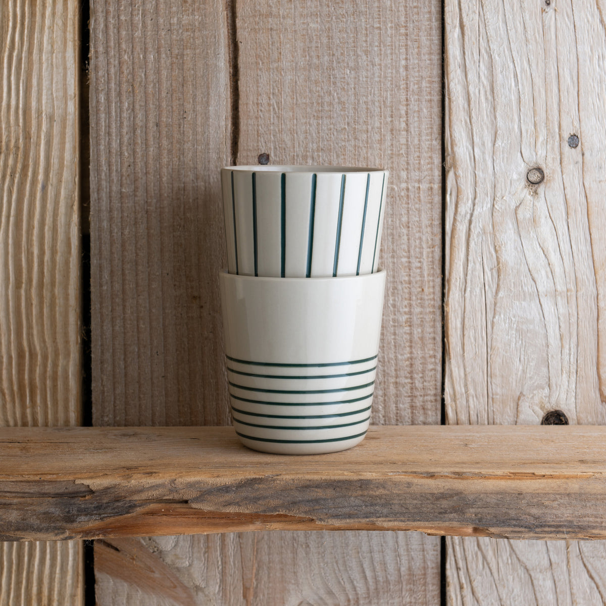 Sea green Sorrel beakers stacked on a weathered wooden shelf