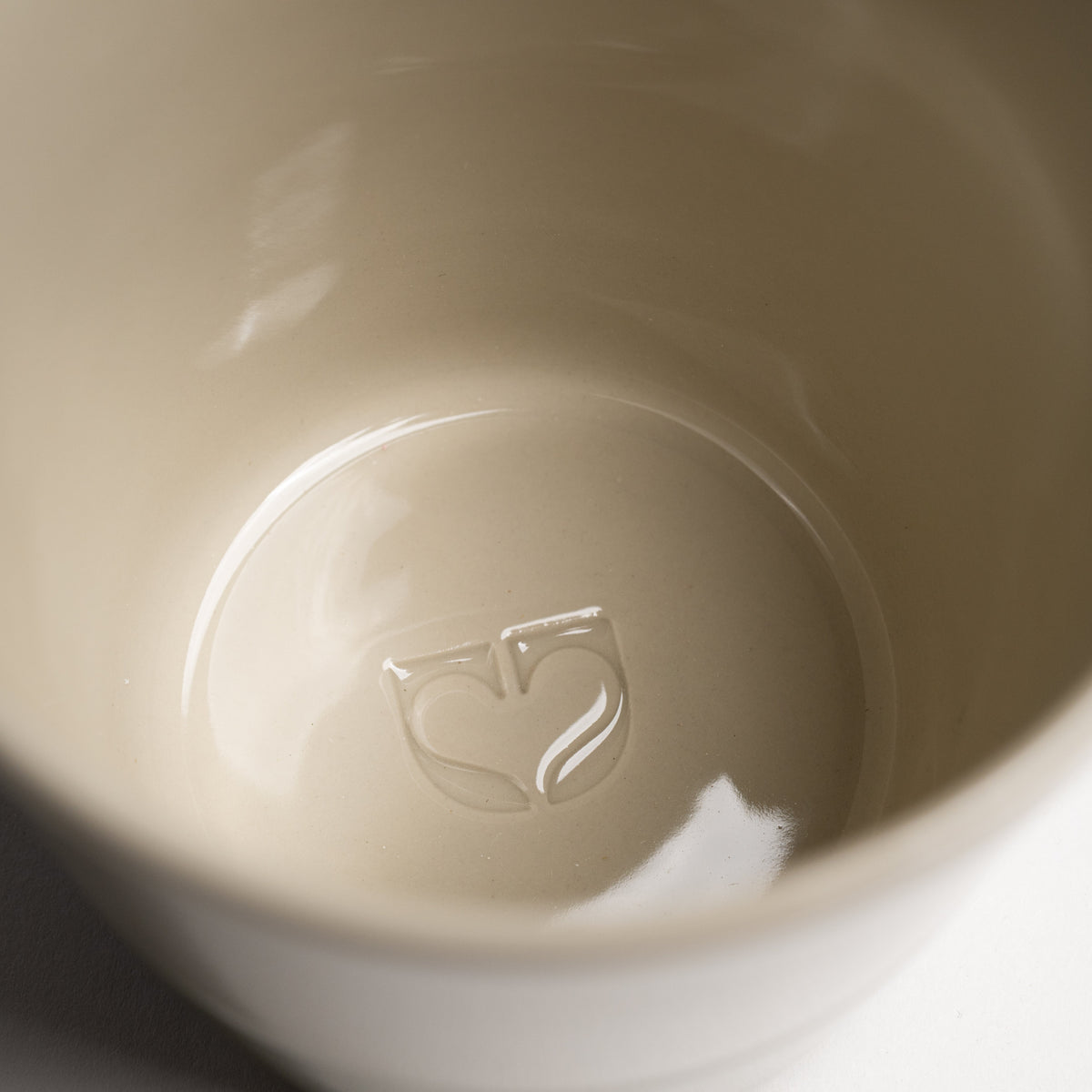Close up of the Kindred icon embossed inside a Sorrel beaker base
