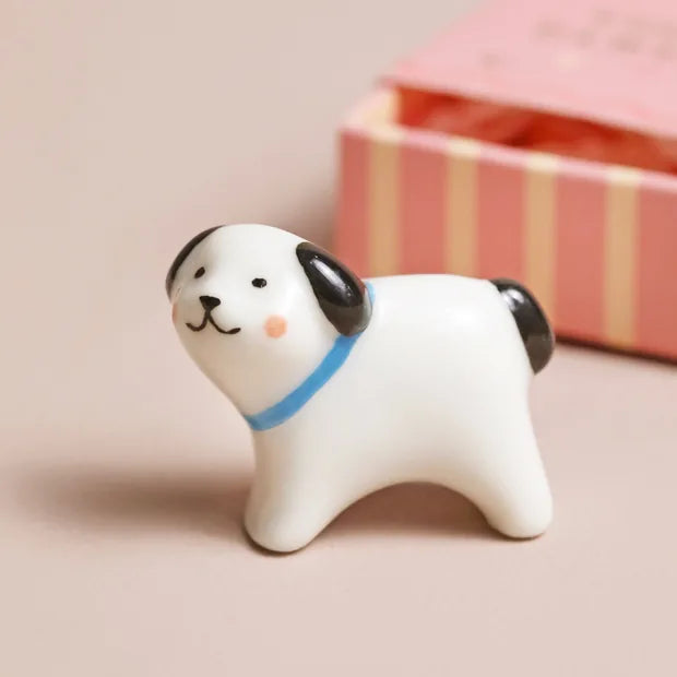 Close-up of ceramic dog with black ears and blue collar detail