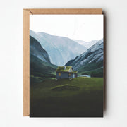 Stryn Sæter greeting card featuring illustrated Nordic cabin in green valley with mountains, paired with kraft envelope.