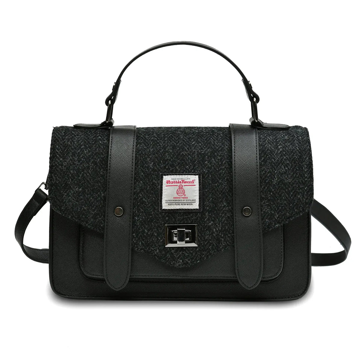 Islander Harris Tweed satchel style handbag in a Black Herringbone design. It has a black synthetic leather body and a shoulder strap lying behind. 